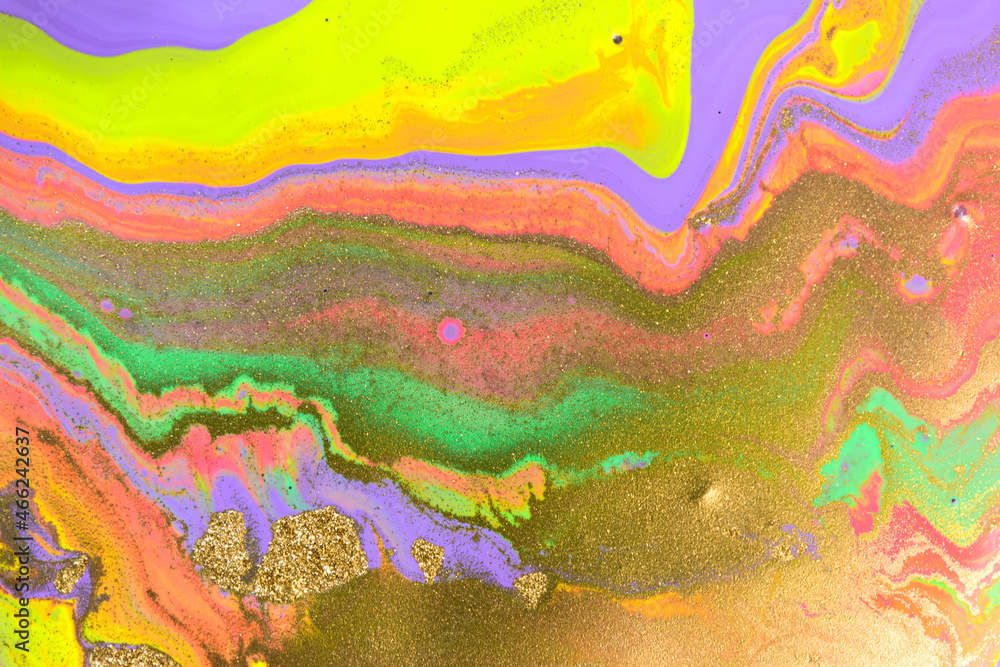 Streams of liquid purple, pink, green and gold ink curls. Waves of fluid vivid golden fluid paint.