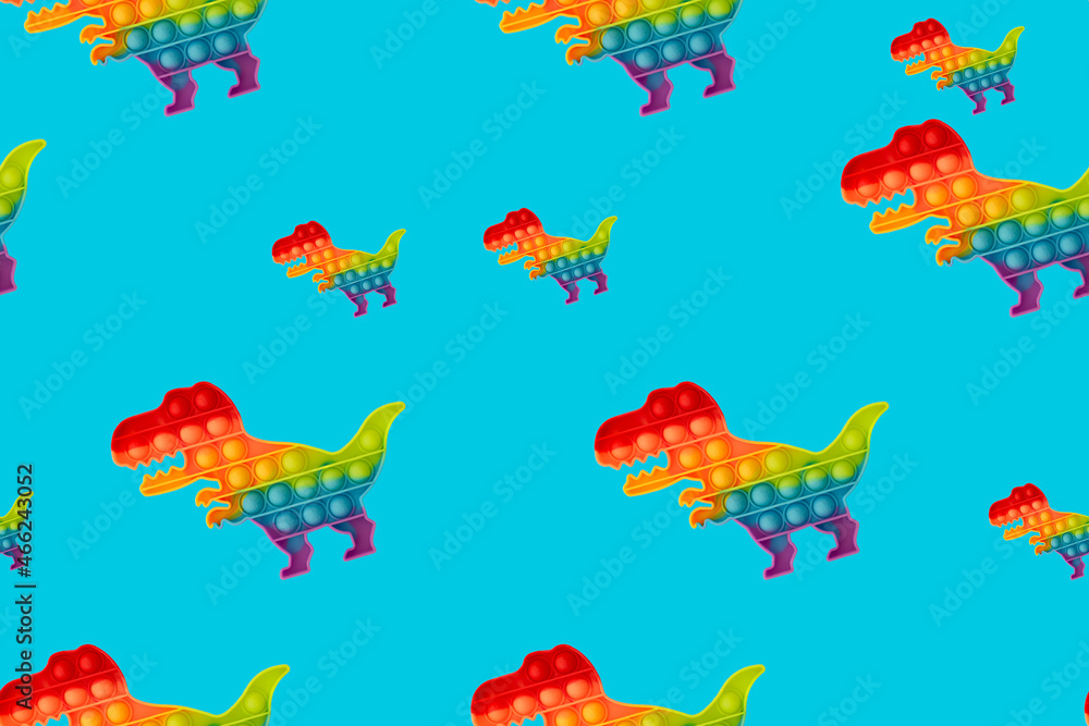Seamless pattern. Toy pop it in the shape of a dinosaur on a turquoise background.