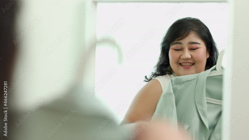 Body positive plus size female clothing. Body positive plus size woman happily and is proud of herself looking at mirror at home Body positive plus size female clothing. Body positive plus size woman happily and is proud of herself looking at mirror at home