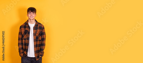 teenager boy isolated on yellow background photo