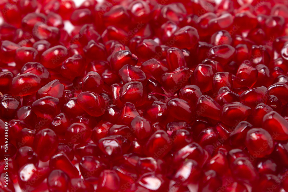 Pomegranate seeds on a white background. Peeled pomegranate in full screen. Pomegranate seeds on a white background. Peeled pomegranate in full screen.