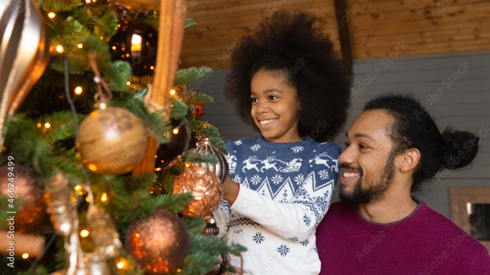 Wide banner panoramic view of smiling African American father and small daughter have fun celebrate Christmas at home. Happy biracial dad and little girl child decorate fir-tree on New Year holidays. Wide banner panoramic view of smiling African American father and small daughter have fun celebrate Christmas at home. Happy biracial dad and little girl child decorate fir-tree on New Year holidays.