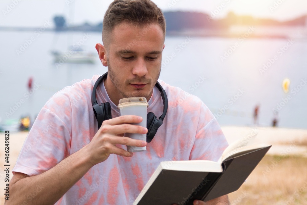 relaxed man with headphones reading a book and having coffee relaxed man with headphones reading a book and having coffee