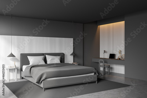 Grey bedroom interior with bed on concrete floor, workplace with computer