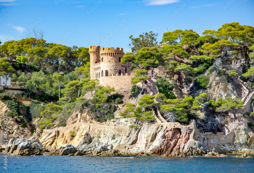 Beautiful wild rocks with castle Sant Joan and coniferous trees on Mediterranean coast in Lloret de Mar, Costa Brava, Spain