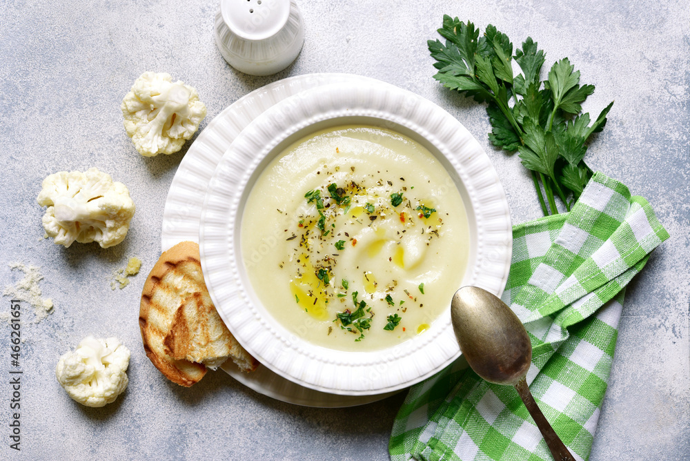 Cauliflower creamy soup with potatoes and cheese. Top view with copy space. Cauliflower creamy soup with potatoes and cheese. Top view with copy space.