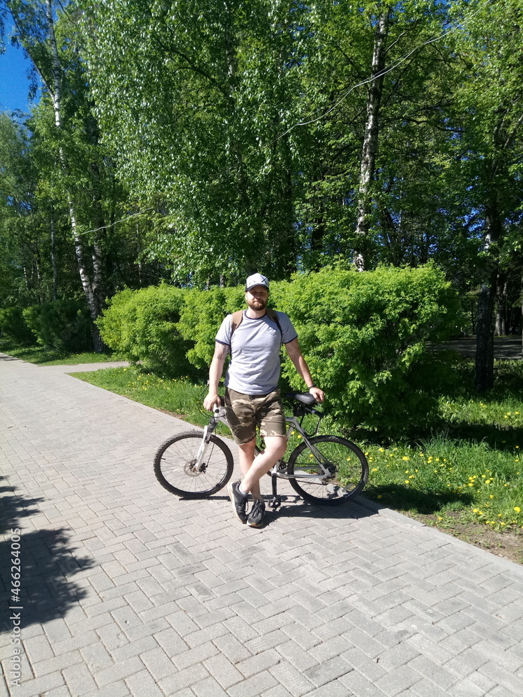 bearded fat man on a bicycle in summer
