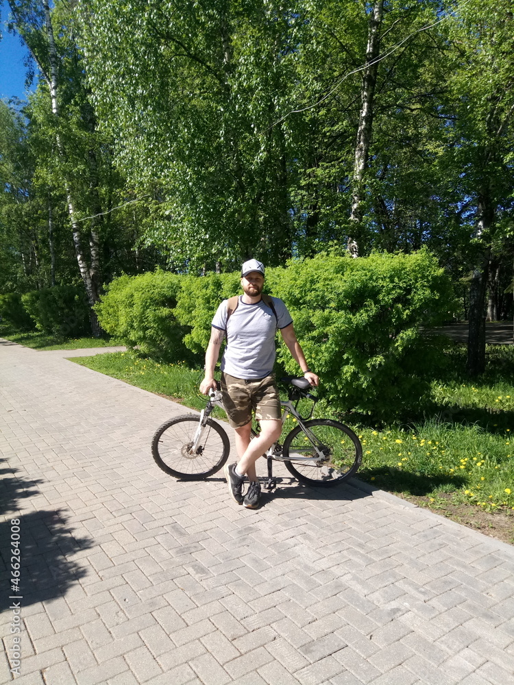 bearded fat man on a bicycle in summer

