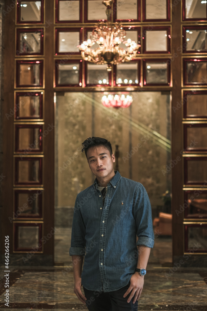 Portrait of asian young handsome man in denim shirt standing and smiling. Chinese people, real life, looking at camera with copy space Portrait of asian young handsome man in denim shirt standing and smiling. Chinese people, real life, looking at camera with copy space