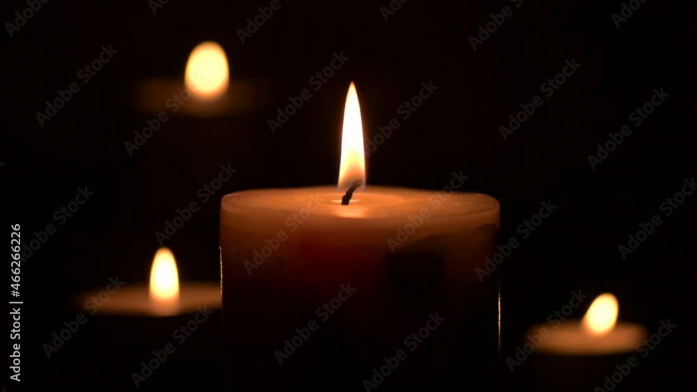 burning three candles, dark background, posting in the frame, slow motion video