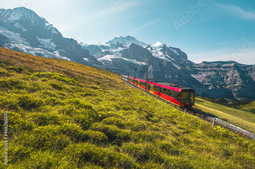 Electric modern tourist train and snowy mountains in background, Switzerland