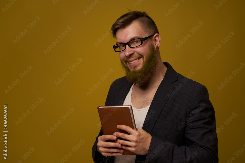 bearded man in a black jacket with a book in his hands education bearded man in a black jacket with a book in his hands education