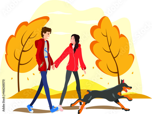 happy couple walks with a dog in the autumn park