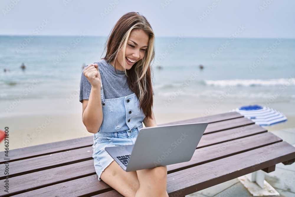 Young caucasian woman working using computer laptop outdoors screaming proud, celebrating victory and success very excited with raised arm