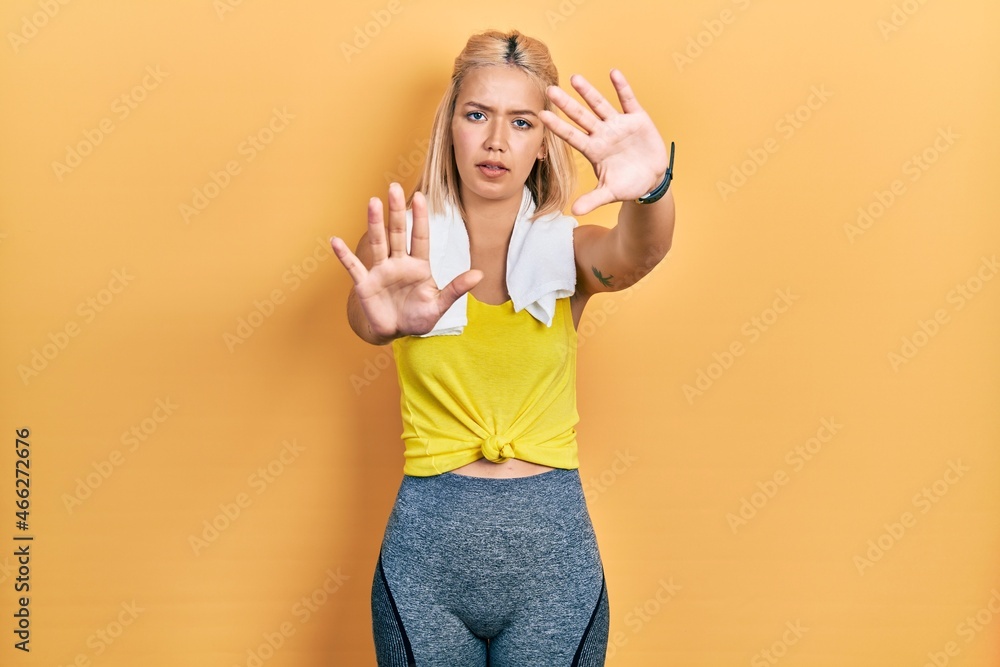 Beautiful blonde sports woman wearing workout outfit doing frame using hands palms and fingers, camera perspective