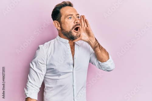 Middle age man wearing casual clothes shouting and screaming loud to side with hand on mouth. communication concept.