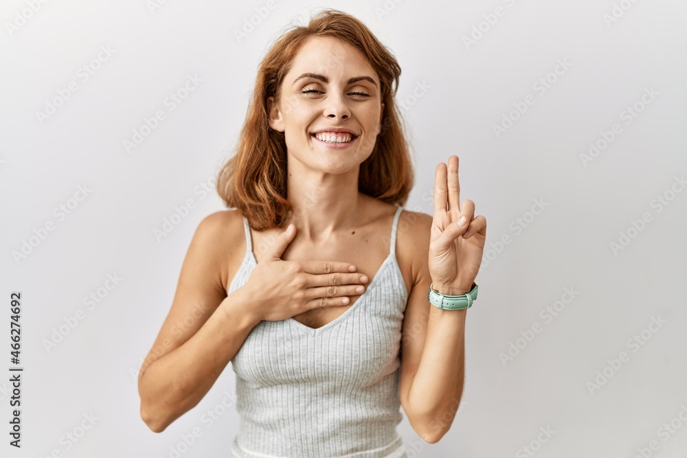Beautiful caucasian woman standing over isolated background smiling swearing with hand on chest and fingers up, making a loyalty promise oath Beautiful caucasian woman standing over isolated background smiling swearing with hand on chest and fingers up, making a loyalty promise oath
