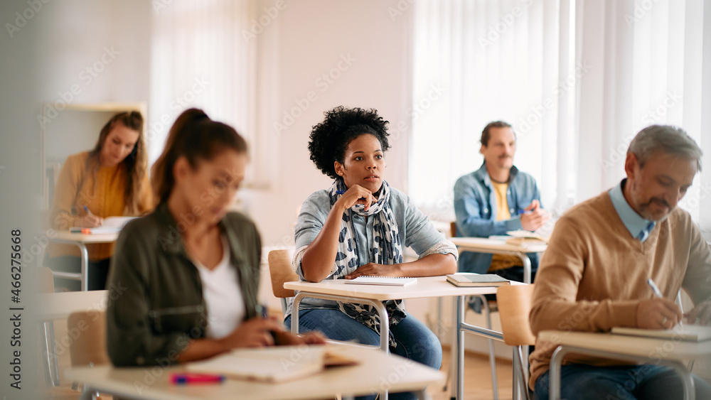 African American female student pays attention on class at lecture hall. African American female student pays attention on class at lecture hall.