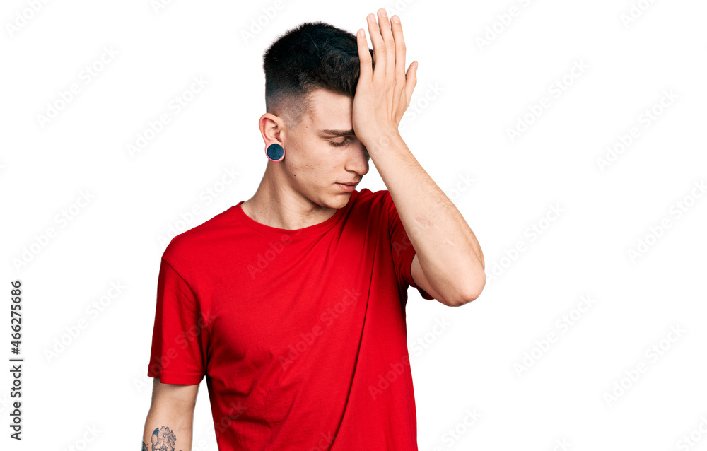 Young caucasian boy with ears dilation wearing casual red t shirt surprised with hand on head for mistake, remember error. forgot, bad memory concept. Young caucasian boy with ears dilation wearing casual red t shirt surprised with hand on head for mistake, remember error. forgot, bad memory concept.