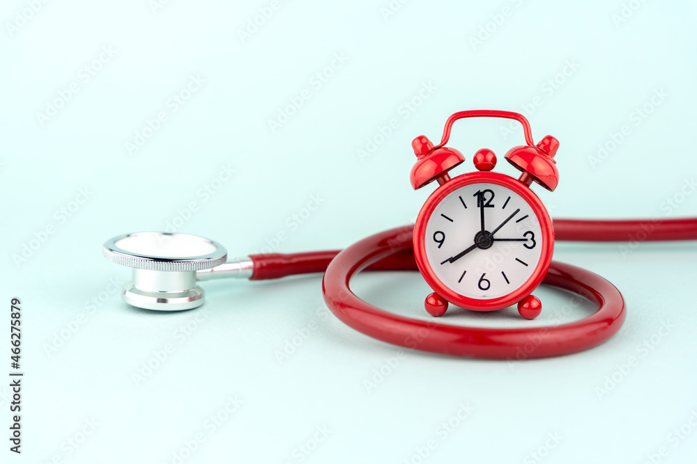 red alarm clock and stethoscope, treatment concept red alarm clock and stethoscope, treatment concept
