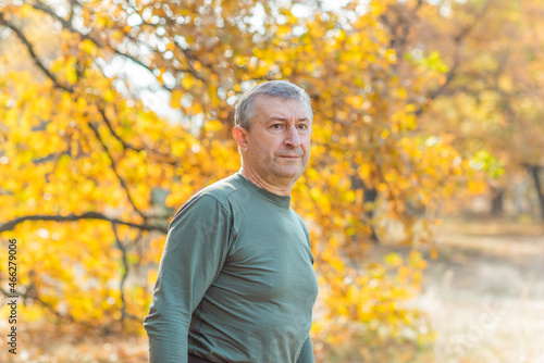 Mature European older man at nature, philosophical portrait, at autumn park
