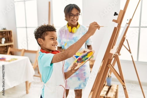 Brother and sister wearing headphones drawing at art studio