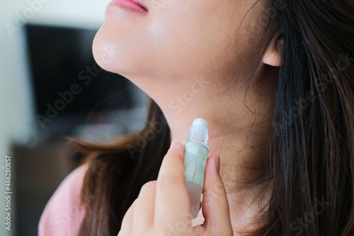 A woman using essence oil in her neck photo