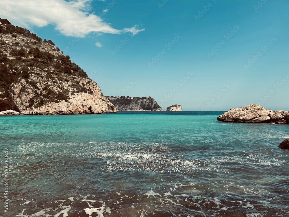 View of a rocky beach with a turquoise sea in Javea, Alicante, Spain.