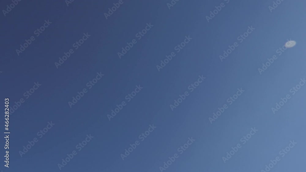 Slow motion of a coin toss against a blue sky Slow motion of a coin toss against a blue sky