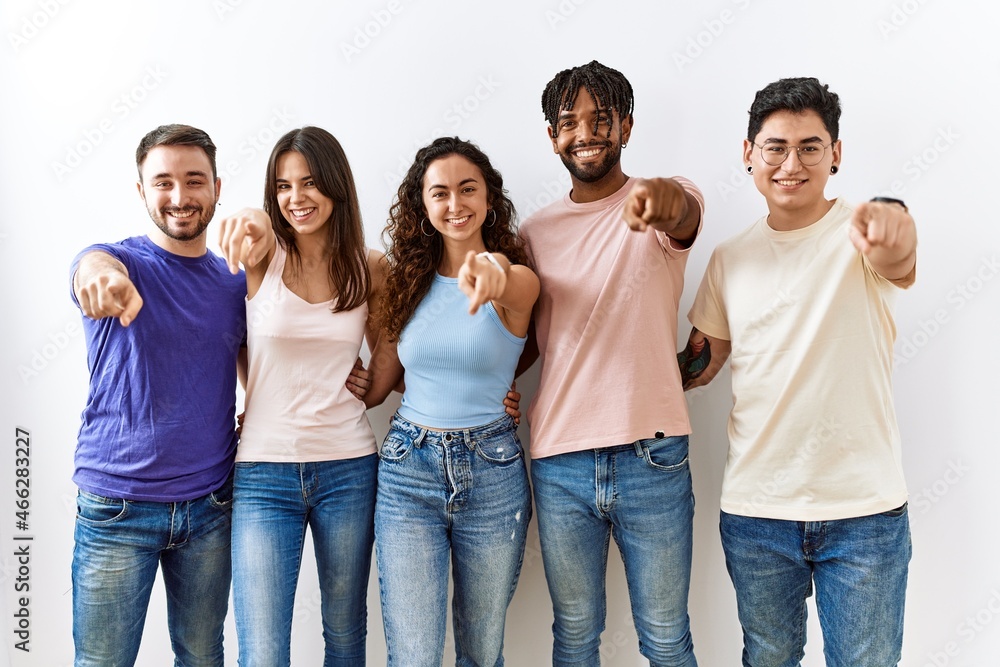 Group of young people standing together over isolated background pointing to you and the camera with fingers, smiling positive and cheerful Group of young people standing together over isolated background pointing to you and the camera with fingers, smiling positive and cheerful