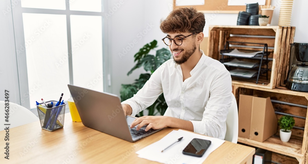 Young arab man using laptop working at office