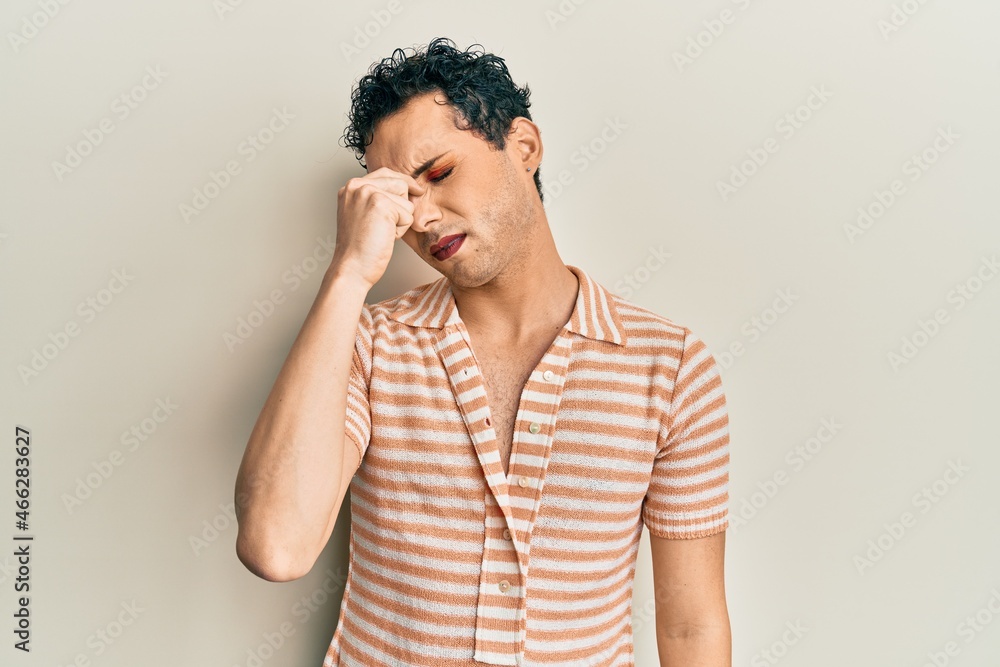 Handsome man wearing make up wearing casual t shirt tired rubbing nose and eyes feeling fatigue and headache. stress and frustration concept. Handsome man wearing make up wearing casual t shirt tired rubbing nose and eyes feeling fatigue and headache. stress and frustration concept.