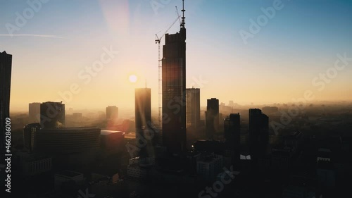 Modern business districtcity glass skyscrapers drone zoom in close to the buildings. Skyscraper in the big city top view during the sunrise when first sun rays are going through the glass windows. photo