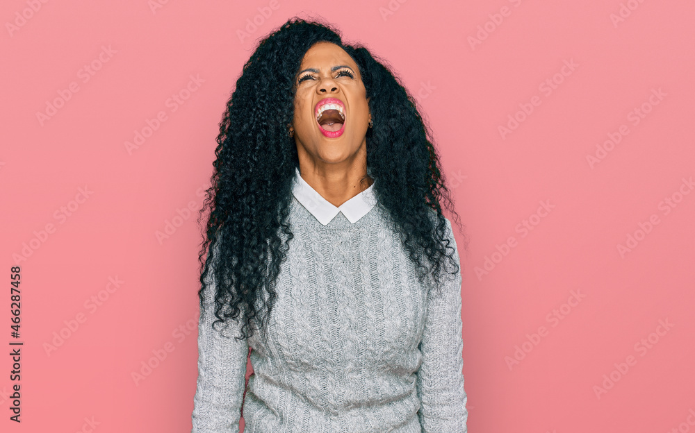 Middle age african american woman wearing casual clothes angry and mad screaming frustrated and furious, shouting with anger. rage and aggressive concept. Middle age african american woman wearing casual clothes angry and mad screaming frustrated and furious, shouting with anger. rage and aggressive concept.