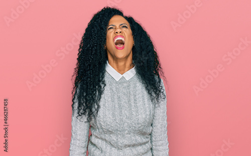 Middle age african american woman wearing casual clothes angry and mad screaming frustrated and furious, shouting with anger. rage and aggressive concept. © Krakenimages.com