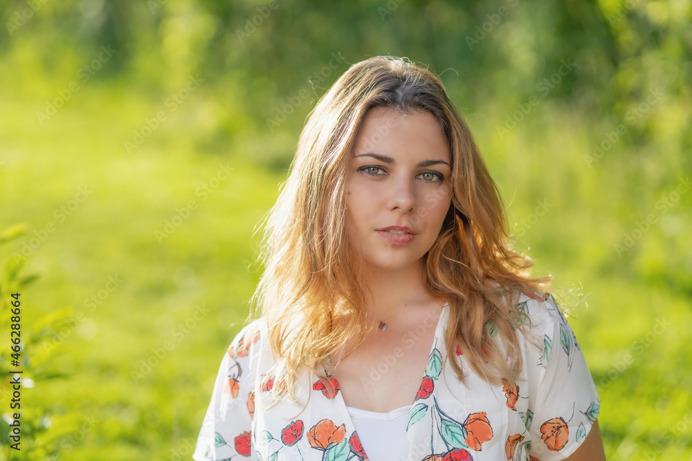 Atractive beautiful  young woman is posing outdoors. Horizontally. 