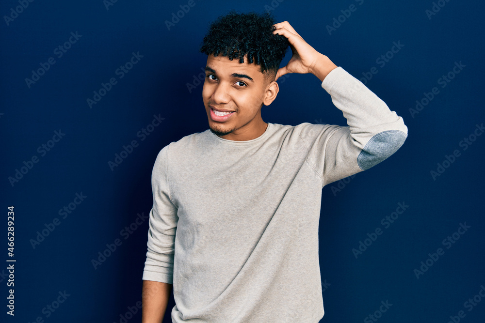 Young african american man wearing casual clothes confuse and wonder about question. uncertain with doubt, thinking with hand on head. pensive concept. Young african american man wearing casual clothes confuse and wonder about question. uncertain with doubt, thinking with hand on head. pensive concept.