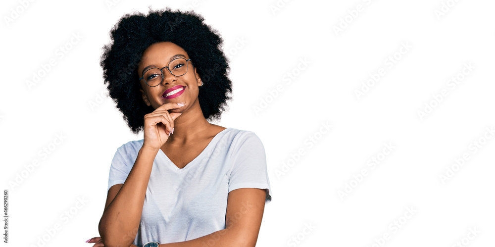 Young african american woman wearing casual white t shirt looking confident at the camera smiling with crossed arms and hand raised on chin. thinking positive. Young african american woman wearing casual white t shirt looking confident at the camera smiling with crossed arms and hand raised on chin. thinking positive.