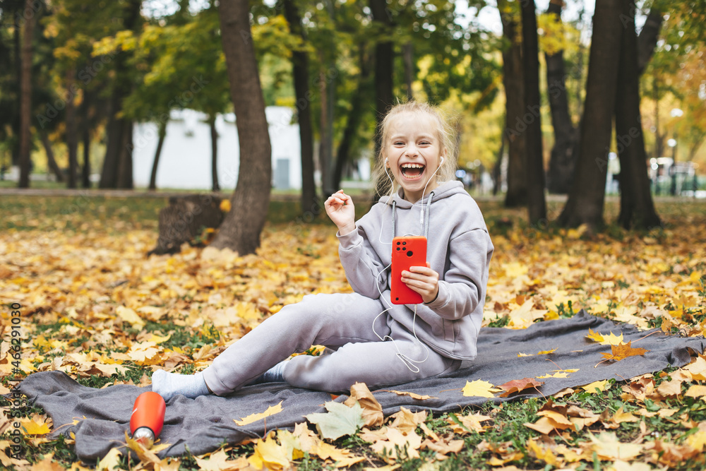Gen z teenage girl using smartphote outdoors in autumn time. Gen z teenage girl using smartphote outdoors in autumn time.