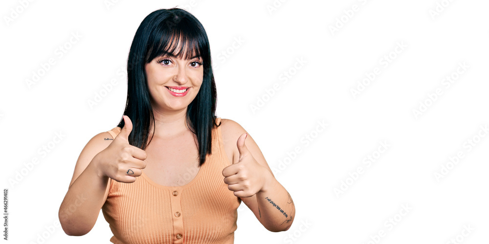 Young hispanic plus size woman wearing casual clothes approving doing positive gesture with hand, thumbs up smiling and happy for success. winner gesture. Young hispanic plus size woman wearing casual clothes approving doing positive gesture with hand, thumbs up smiling and happy for success. winner gesture.