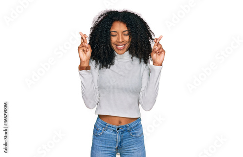 Young african american girl wearing casual clothes gesturing finger crossed smiling with hope and eyes closed. luck and superstitious concept.
