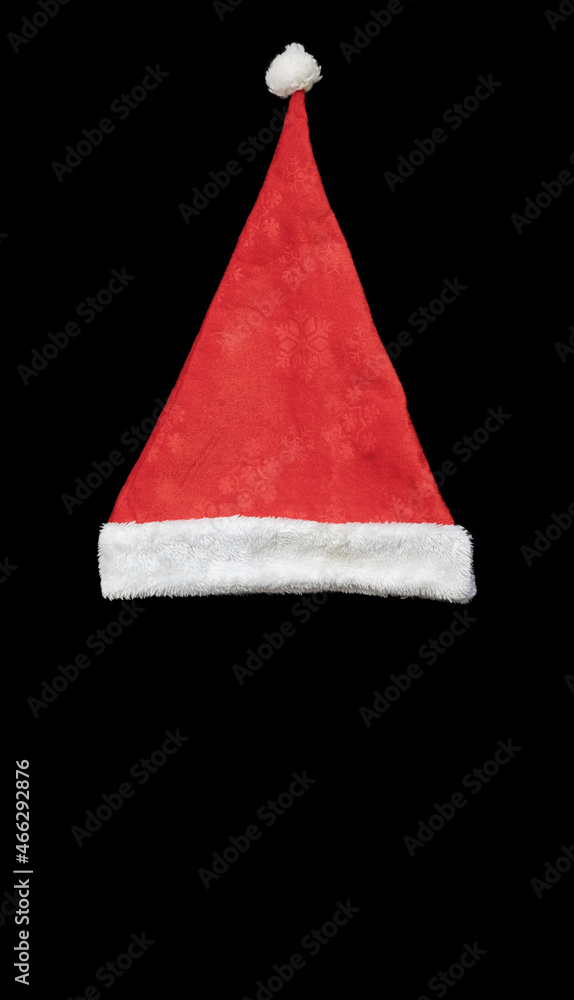 Red santa hat with white bubo and edging on a black background. Top view