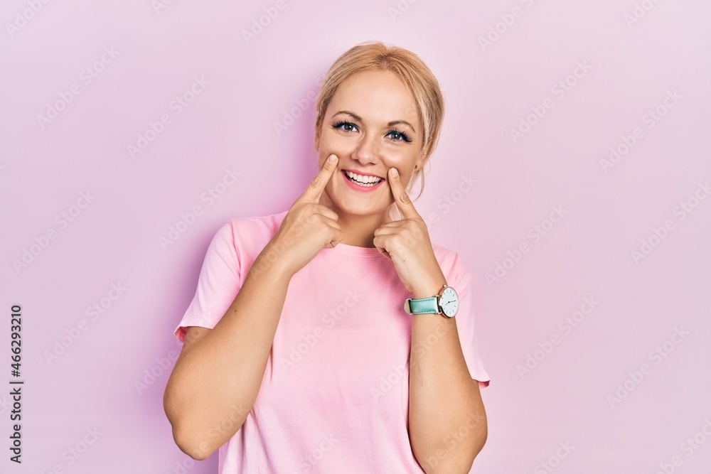 Young blonde woman wearing casual pink t shirt smiling with open mouth, fingers pointing and forcing cheerful smile Young blonde woman wearing casual pink t shirt smiling with open mouth, fingers pointing and forcing cheerful smile