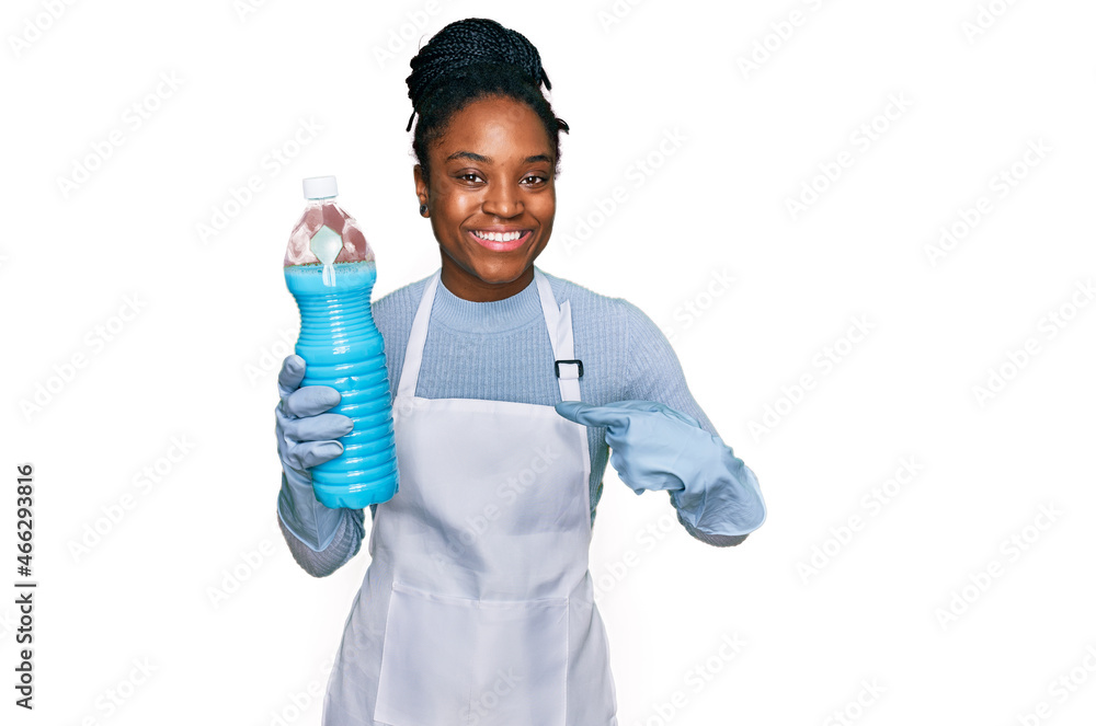 Young african american woman wearing apron holding detergent bottle pointing finger to one self smiling happy and proud Young african american woman wearing apron holding detergent bottle pointing finger to one self smiling happy and proud