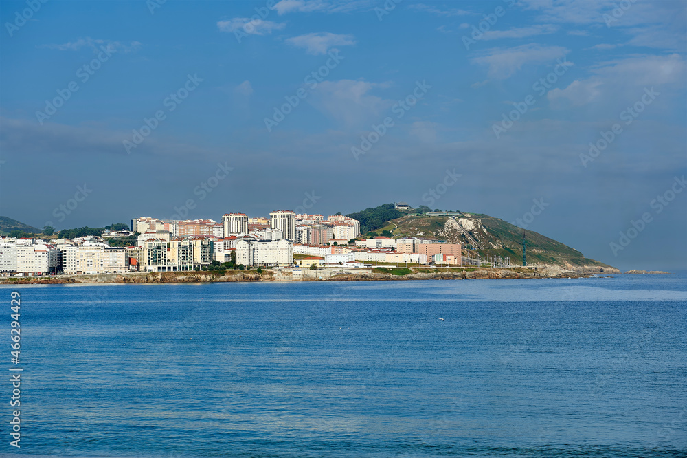 residential buildings and apartments in the Orzan cove in La Coruña with morning fog and the San Pedro mountain in the background