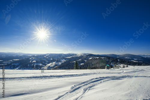 ATV and ski tracks in snow on frosty winter day © YouraPechkin