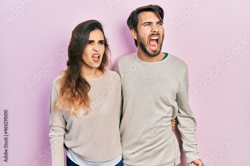 Young hispanic couple wearing casual clothes angry and mad screaming frustrated and furious, shouting with anger. rage and aggressive concept.