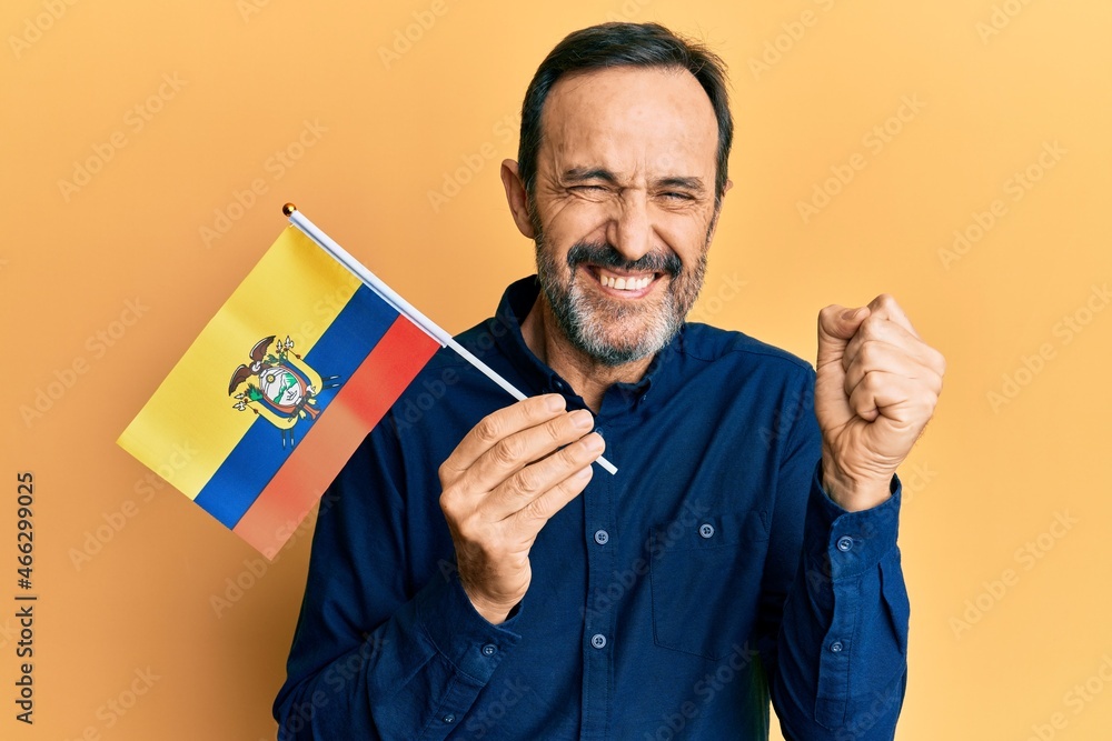 Middle age hispanic man holding ecuador flag screaming proud, celebrating victory and success very excited with raised arm Middle age hispanic man holding ecuador flag screaming proud, celebrating victory and success very excited with raised arm
