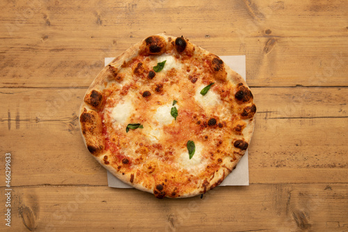 Typical Neapolitan margherita pizza with buffalo cheese made with tomato, mozzarella, fresh basil, salt and oil.