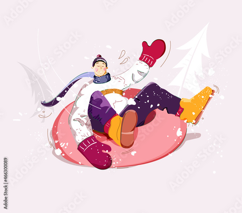 Snow tubing. Boy rides inner tube on snow. Wintertime outdoor activity.